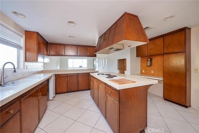 kitchen with tasteful backsplash, a center island, a healthy amount of sunlight, and custom exhaust hood