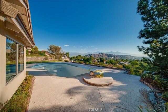 view of swimming pool featuring a mountain view and a patio