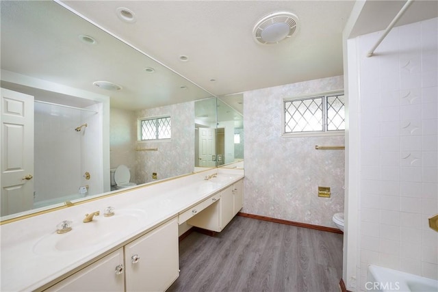 full bathroom with wood-type flooring, vanity, bathing tub / shower combination, and toilet