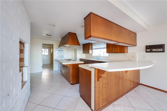 kitchen with sink, kitchen peninsula, white appliances, a kitchen bar, and light tile patterned floors