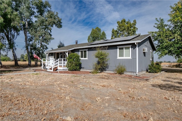 ranch-style house featuring a sunroom and solar panels