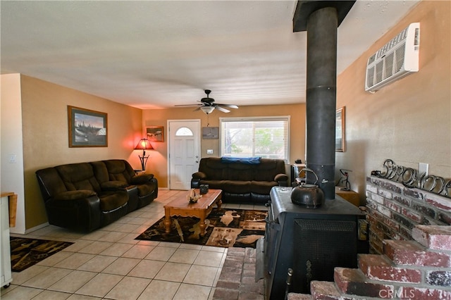 living room with ceiling fan, a wood stove, light tile patterned floors, and a wall mounted air conditioner