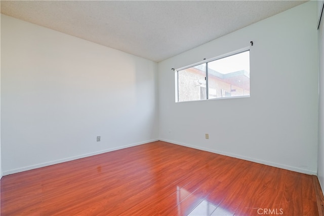 unfurnished room featuring a textured ceiling and hardwood / wood-style flooring