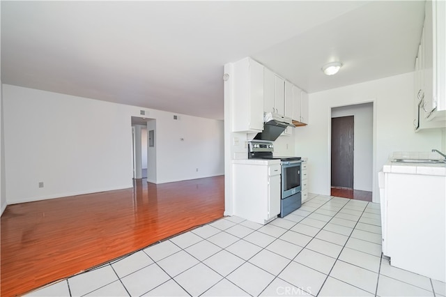 kitchen featuring light hardwood / wood-style floors, stainless steel electric stove, white cabinets, and sink