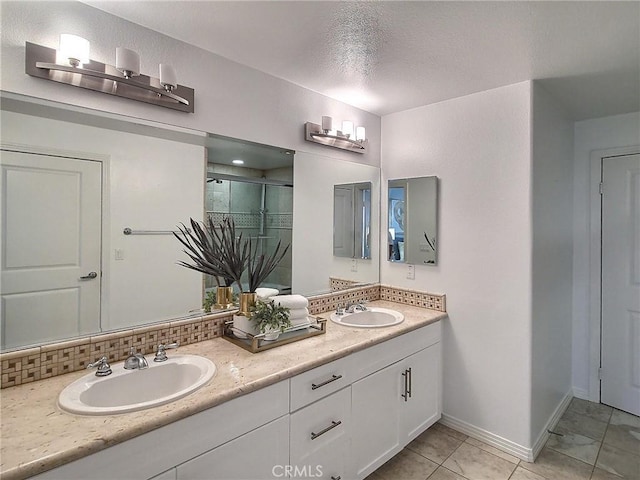 bathroom with decorative backsplash, tile patterned floors, walk in shower, vanity, and a textured ceiling