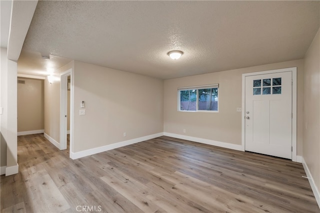 foyer entrance featuring a textured ceiling and light hardwood / wood-style flooring