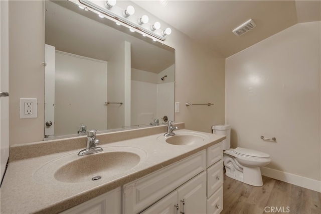 bathroom with vanity, toilet, and hardwood / wood-style floors