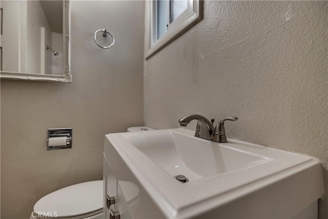 half bath featuring toilet and vanity