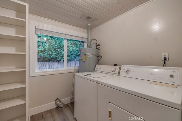 laundry room with laundry area, light wood-style flooring, secured water heater, baseboards, and washer and clothes dryer