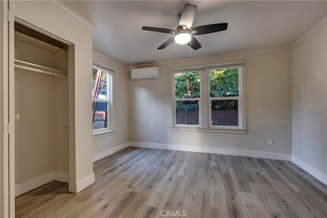 unfurnished bedroom featuring crown molding, an AC wall unit, multiple windows, and wood finished floors