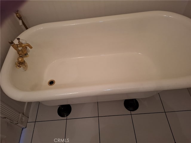 bathroom with a tub to relax in and tile patterned flooring