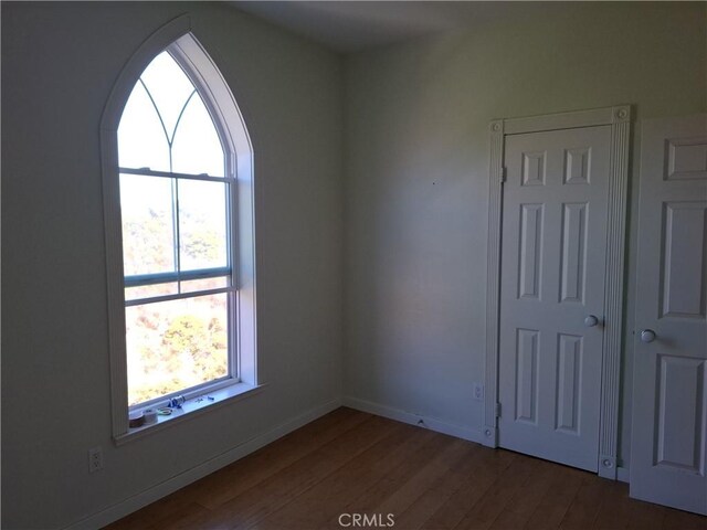 unfurnished room featuring dark wood-type flooring