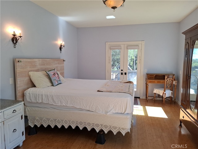 bedroom with french doors, access to exterior, and hardwood / wood-style floors