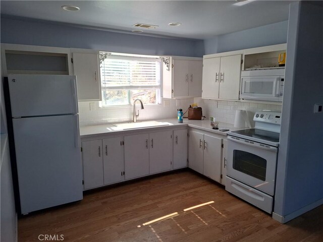 kitchen featuring decorative backsplash, dark hardwood / wood-style floors, sink, white cabinetry, and white appliances