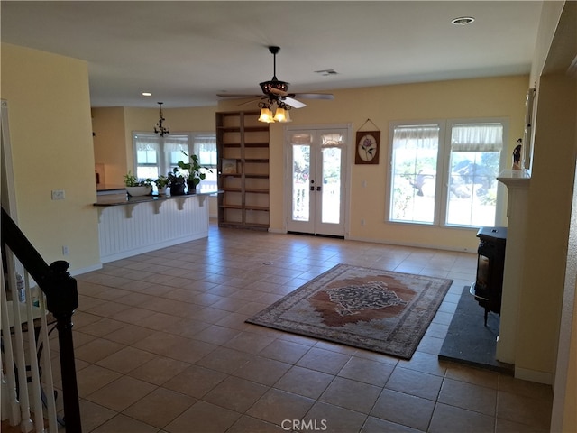 unfurnished living room with french doors, ceiling fan, and tile patterned flooring