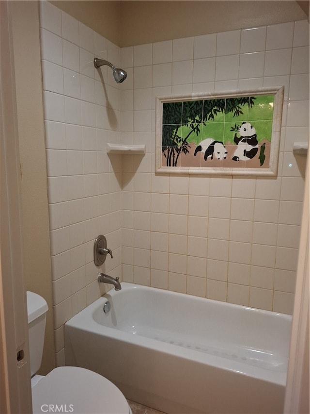 bathroom with toilet and tiled shower / bath