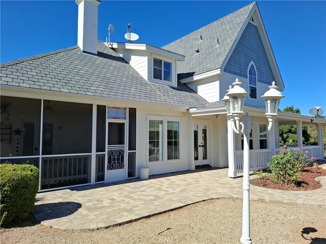 rear view of house featuring a patio area and a sunroom