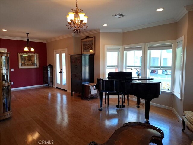 miscellaneous room featuring french doors, crown molding, a notable chandelier, and hardwood / wood-style floors