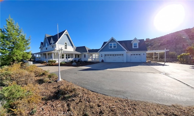 view of front facade with covered porch, a mountain view, and a garage