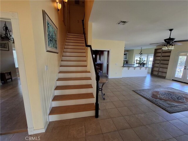 stairs featuring french doors, tile patterned flooring, and ceiling fan