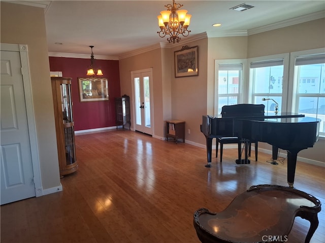 misc room with ornamental molding, a healthy amount of sunlight, hardwood / wood-style flooring, and a chandelier