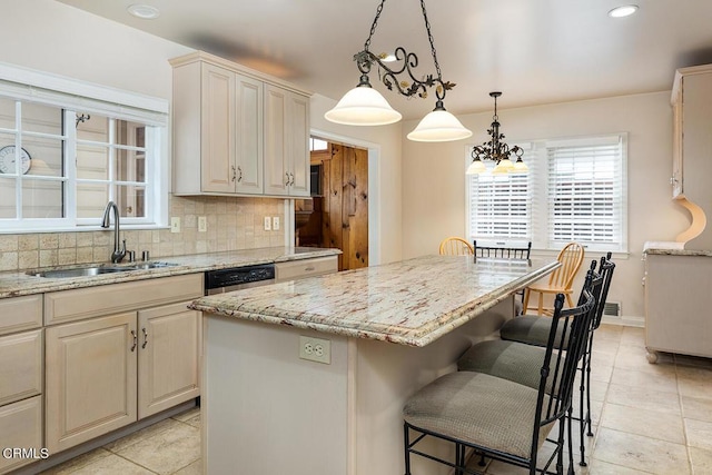 kitchen featuring a center island, sink, hanging light fixtures, decorative backsplash, and a kitchen bar