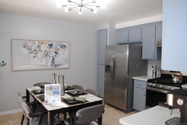 kitchen with light tile patterned flooring, stainless steel appliances, and a notable chandelier