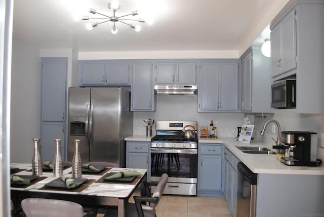 kitchen featuring sink, light tile patterned floors, stainless steel appliances, and an inviting chandelier