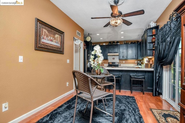 dining room with ceiling fan, sink, and light hardwood / wood-style floors