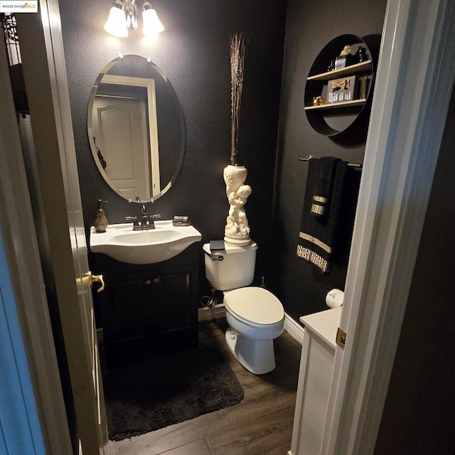 bathroom with vanity, toilet, and wood-type flooring