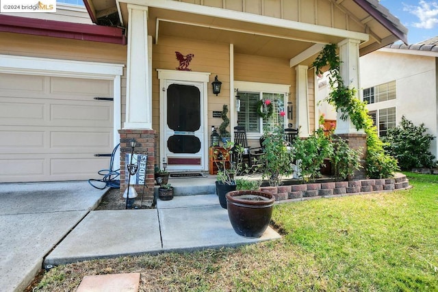 property entrance with a garage, a yard, and covered porch