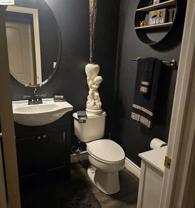 bathroom with vanity, wood-type flooring, and toilet