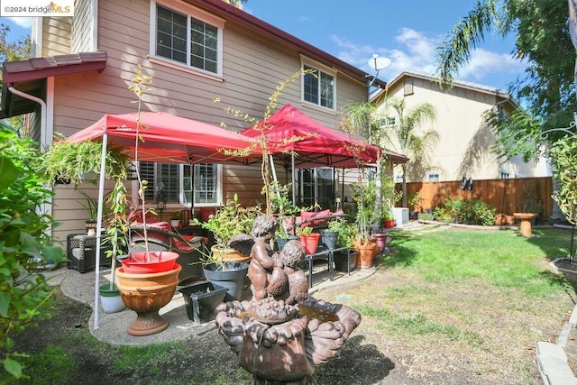 rear view of house with a gazebo and a lawn