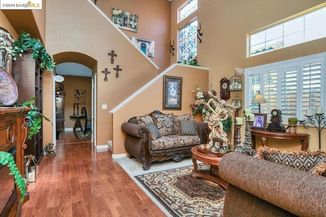 living room featuring hardwood / wood-style floors and a towering ceiling