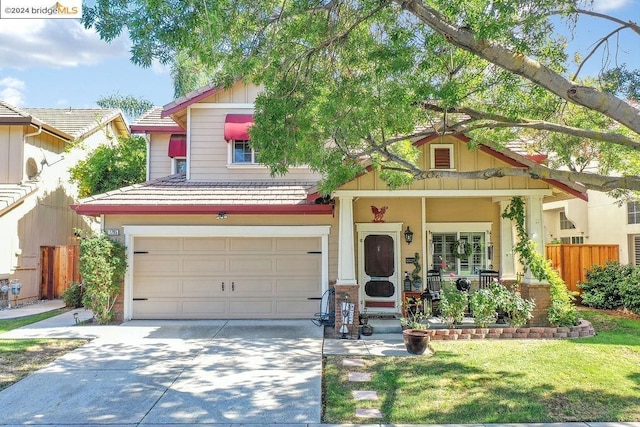 view of front of property with a garage, a front yard, and covered porch