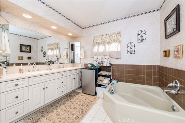 bathroom with vanity, tile patterned floors, and a bath