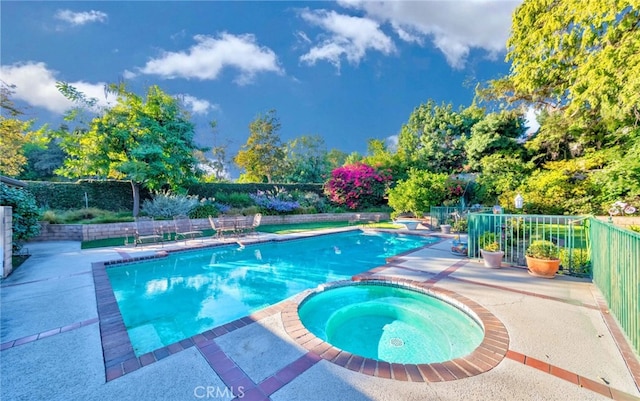 view of swimming pool with an in ground hot tub