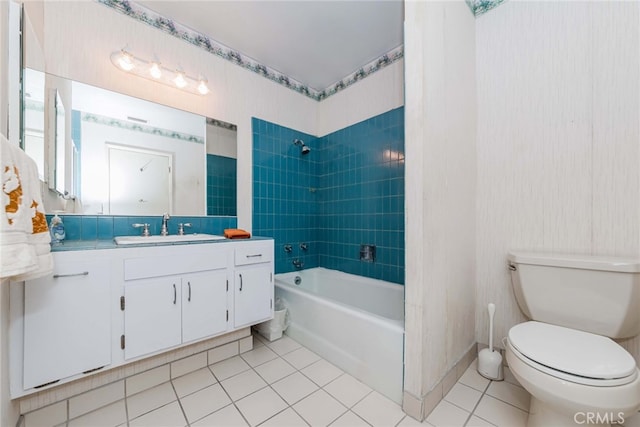 full bathroom with tiled shower / bath, vanity, toilet, and tile patterned floors