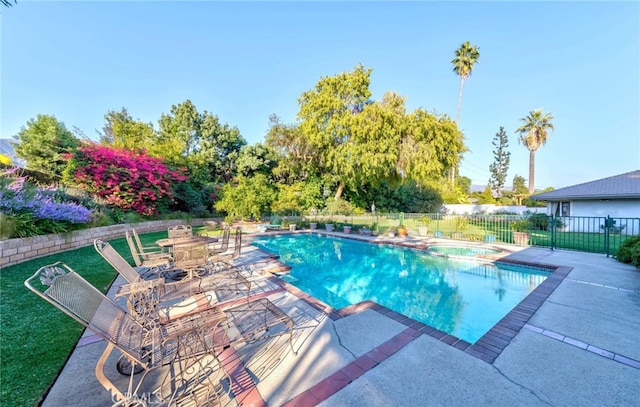 view of swimming pool with an in ground hot tub, a patio area, and a lawn