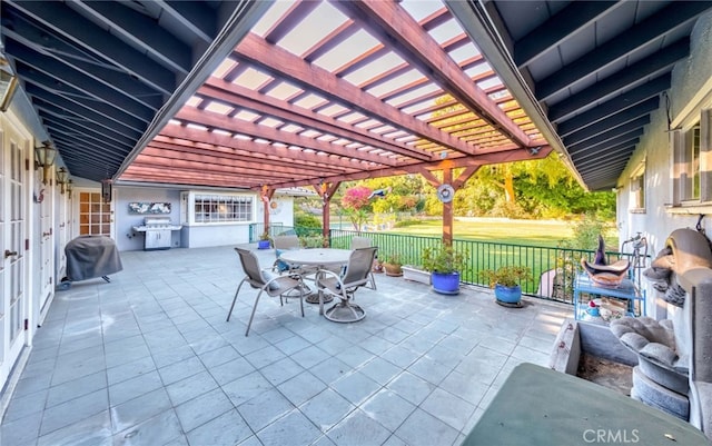 view of patio / terrace featuring exterior kitchen, a grill, and a pergola