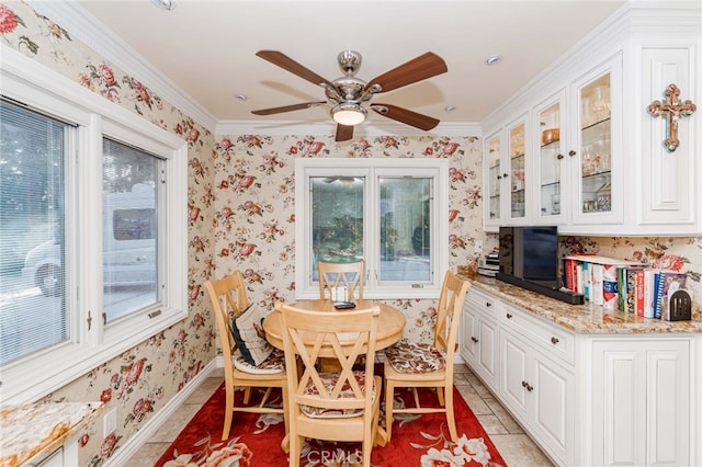 tiled dining space featuring crown molding, a healthy amount of sunlight, and ceiling fan