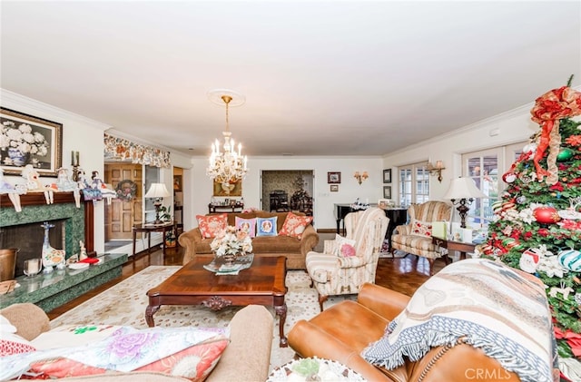 living room with ornamental molding, a chandelier, a fireplace, and hardwood / wood-style floors