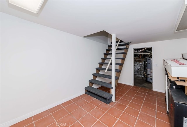 basement with strapped water heater and tile patterned floors