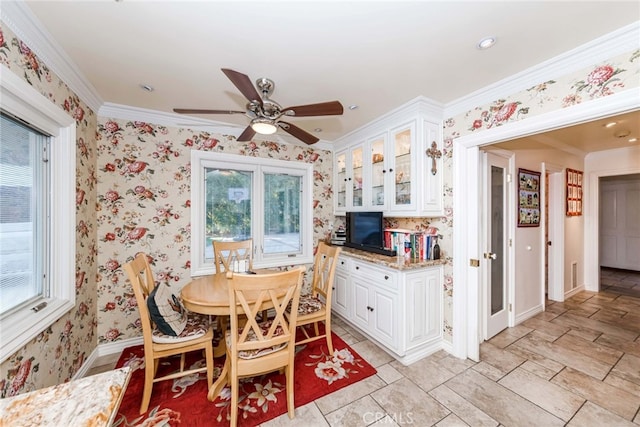 dining space with crown molding, a wealth of natural light, and ceiling fan