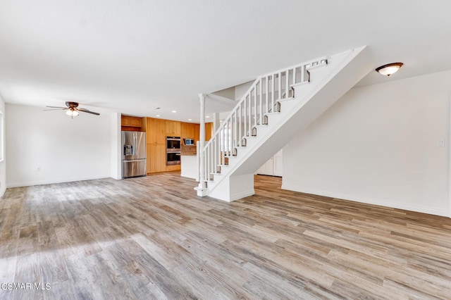 unfurnished living room with light hardwood / wood-style flooring and ceiling fan