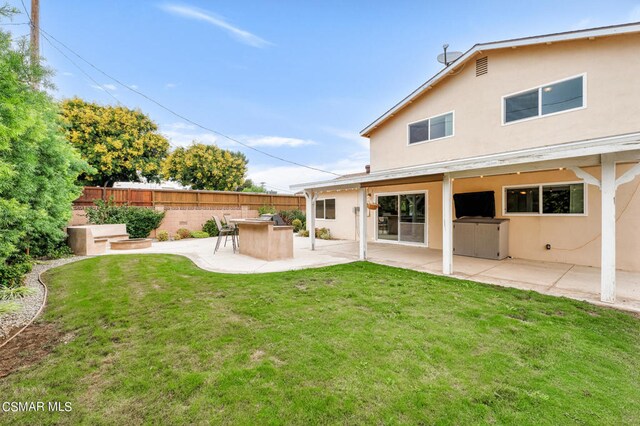 rear view of house featuring a patio and a lawn