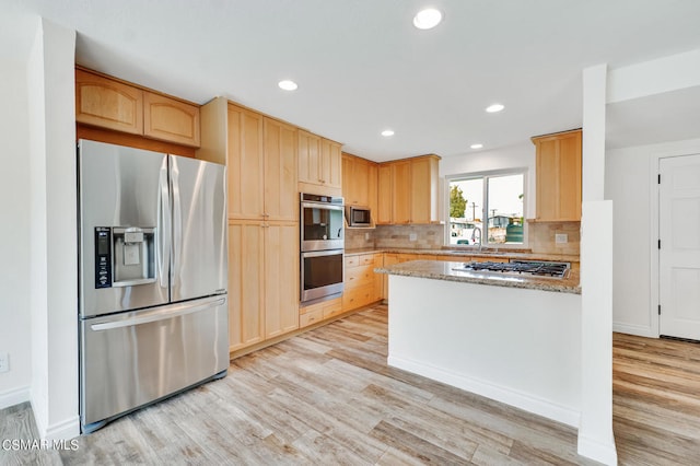 kitchen with light stone counters, stainless steel appliances, and light hardwood / wood-style flooring