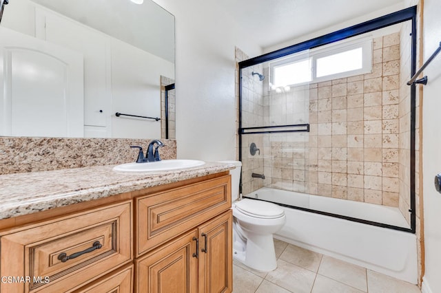 full bathroom with vanity, shower / bath combination with glass door, toilet, and tile patterned flooring