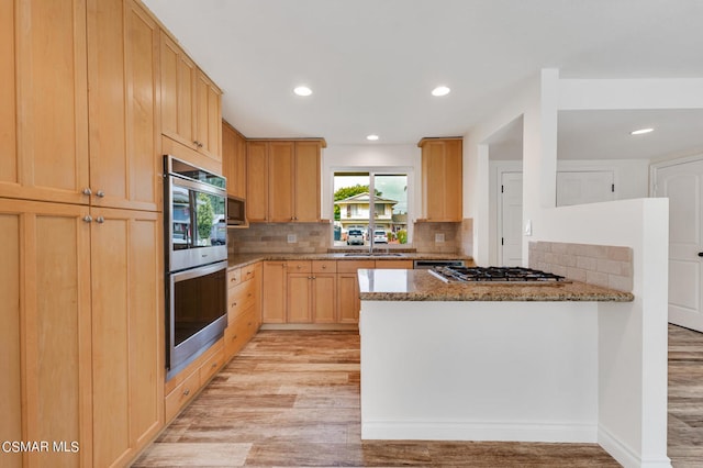 kitchen featuring a healthy amount of sunlight, light stone countertops, and light wood-type flooring