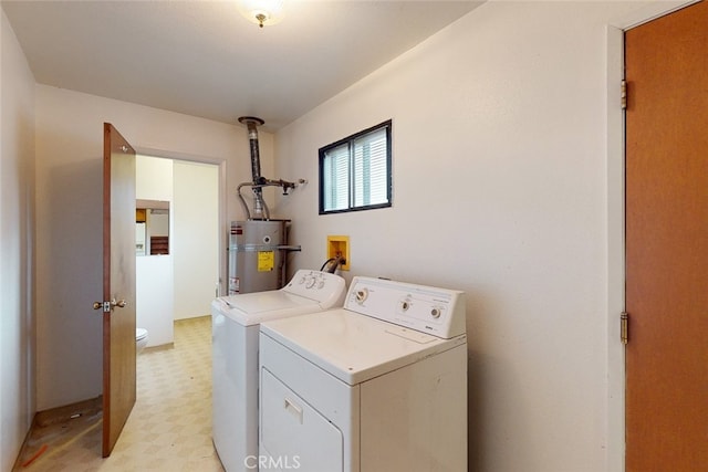 washroom with water heater and independent washer and dryer